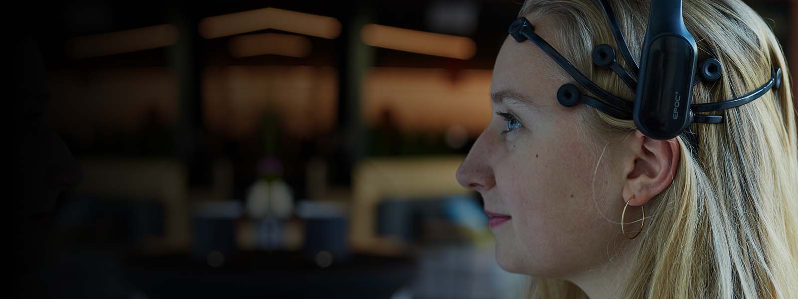 A lady using EEG headset for brain data measuring