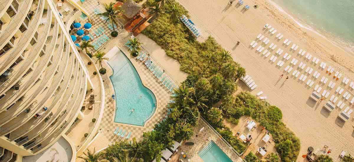 aerial view of hotel pools and tropical beach