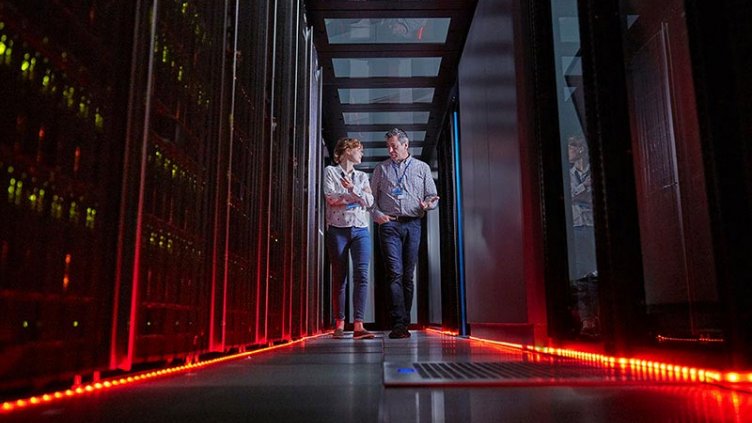 IT technicians talking and walking in dark server room