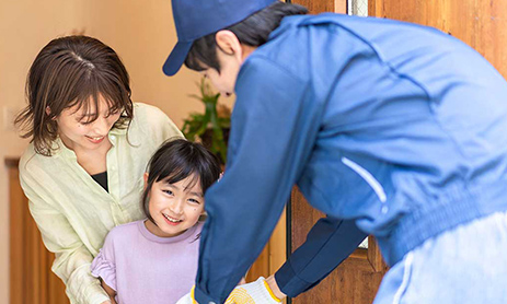 Smiling young woman and her daughter receiving delivery from delivery man at home