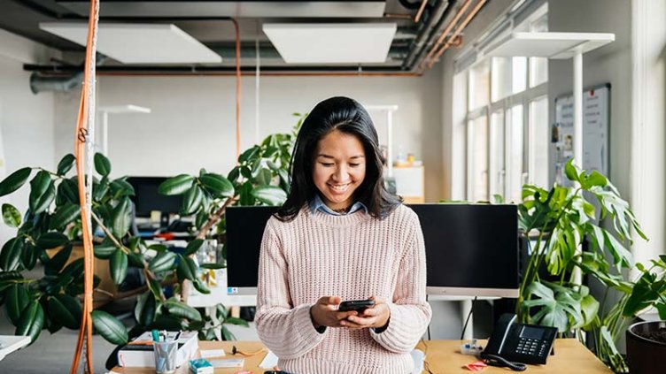 Happy employee in a green office, smiling.