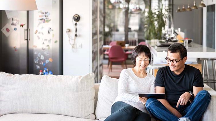 Couples sitting on the sofa and looking on a tab