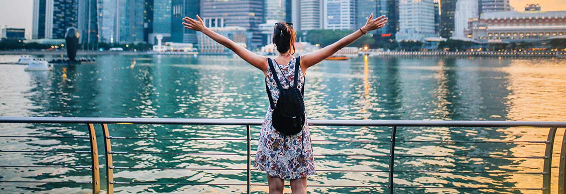 A picture of a woman overlooking a river with Singapore’s skyline in the backdrop