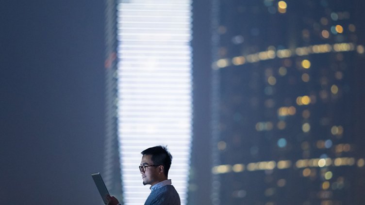 Smart businessman using and looking at digital tablet