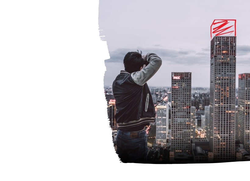 Man taking a photo in front of high rise buildings