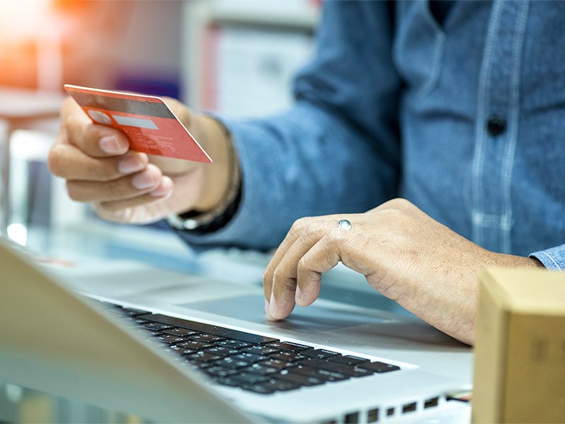 Man holding a credit card, getting ready for online shopping