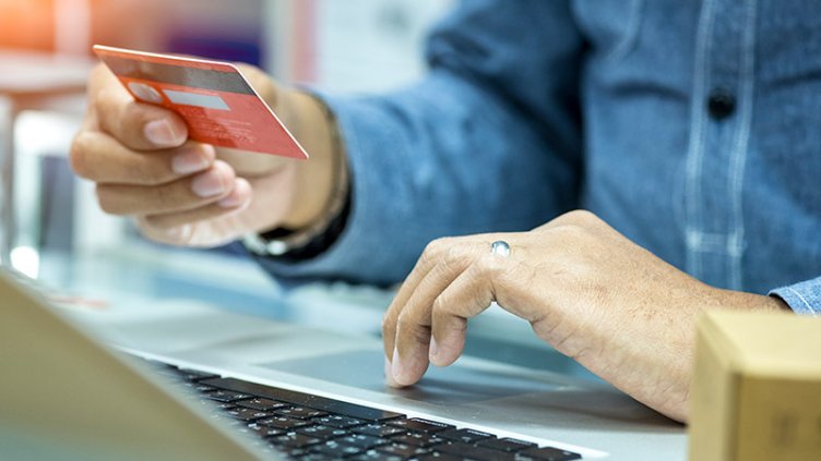 Man holding a credit card, getting ready for online shopping