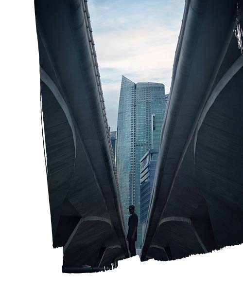 Low angle view man standing admist bridge in the front of skyscraperbuildings against sky