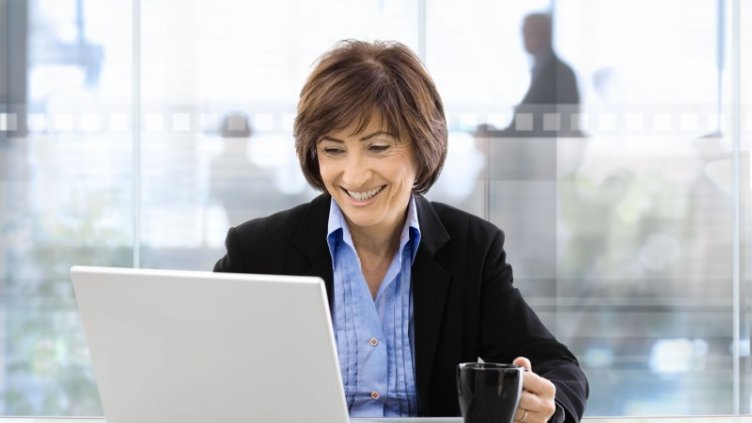 Woman smiling while working on the laptop