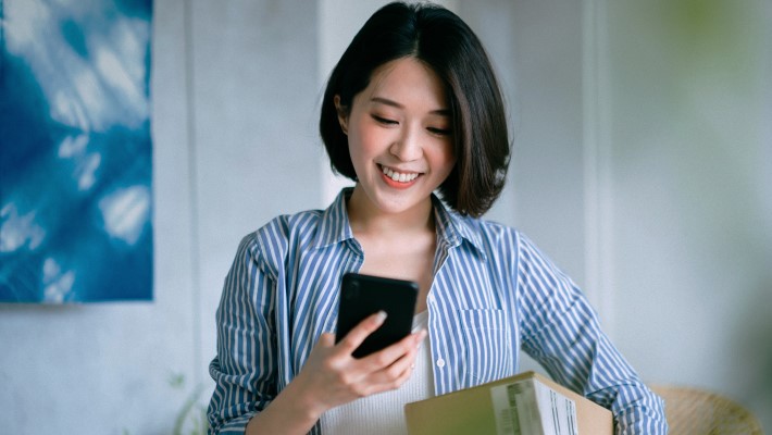 Smiling women scanning QR code on the phone