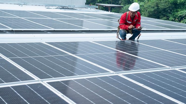 Maintenance engineer inspecting solar panels