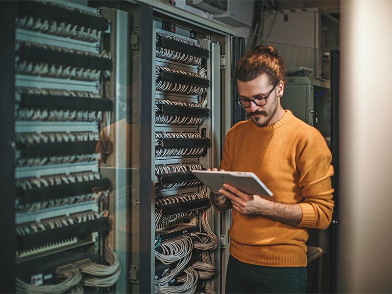 Man working on a tablet in a data center
