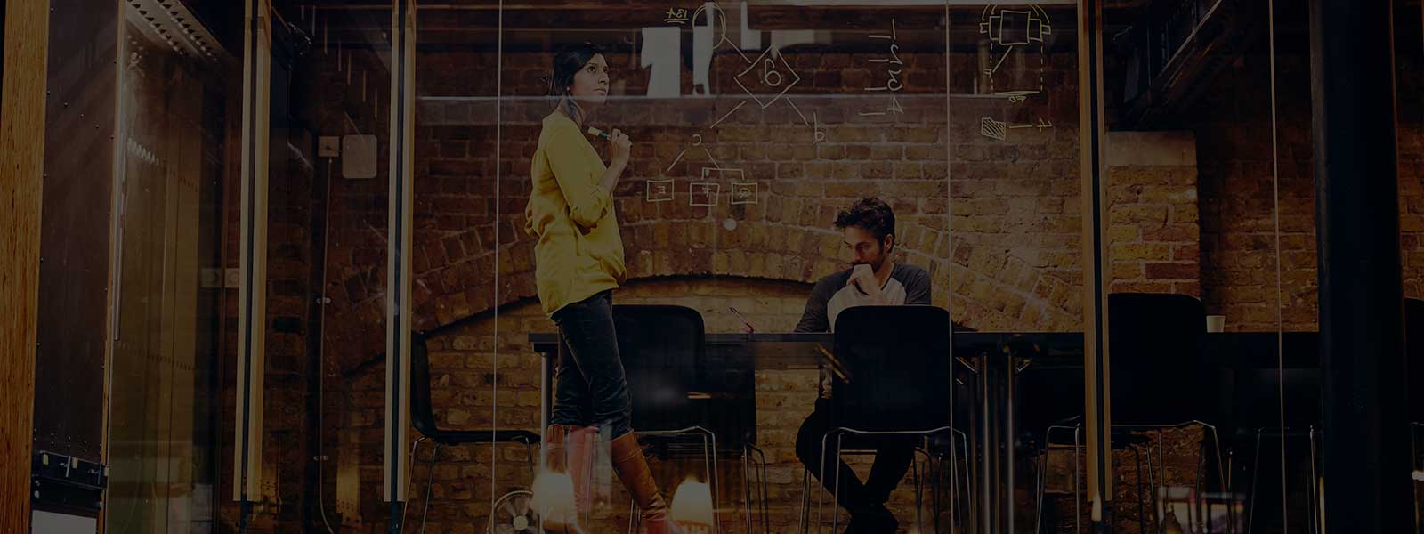 Man and woman working on a project in a meeting room