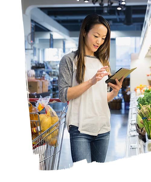 Woman checking shopping list on smartphone in supermarket 