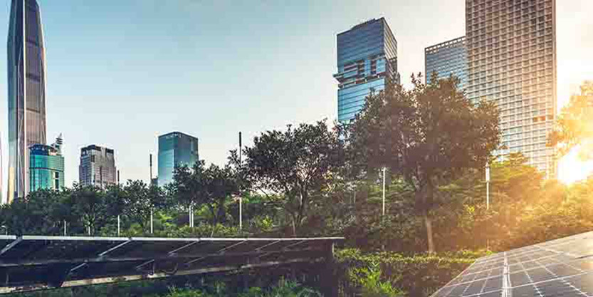 A modern cityscape with trees and a building with solar panels